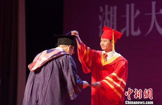 图为，beat365正版唯一官网必一校长赵凌云为毕业生拨穗正冠 向正鹏 摄